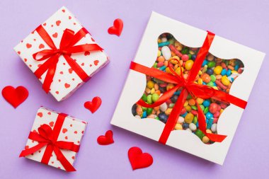 Valentine day composition: sweet candy, with gift boxes with bow and red felt hearts, photo template, background. Top View with copy space.