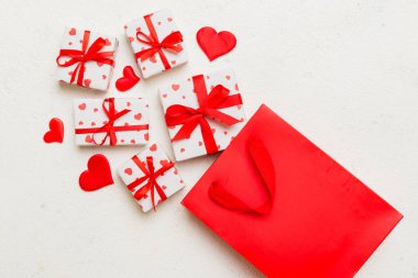 Gift boxes pop out from paper bag top view on colored background. bag packing handmade boxes fall out Concept of holidays, shopping, sale, discounts. Top view, flat lay.