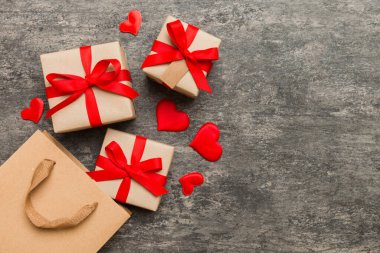 Gift boxes pop out from paper bag top view on colored background. bag packing handmade boxes fall out Concept of holidays, shopping, sale, discounts. Top view, flat lay.