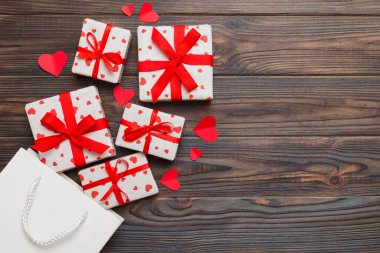 Gift boxes pop out from paper bag top view on colored background. bag packing handmade boxes fall out Concept of holidays, shopping, sale, discounts. Top view, flat lay.