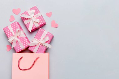 Gift boxes pop out from paper bag top view on colored background. bag packing handmade boxes fall out Concept of holidays, shopping, sale, discounts. Top view, flat lay.