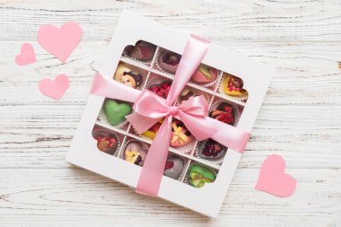 Valentine day composition: sweet candy, with gift boxes with bow and red felt hearts, photo template, background. Top View with copy space.
