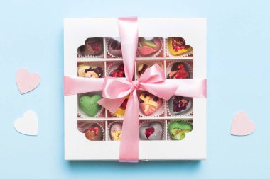 Valentine day composition: sweet candy, with gift boxes with bow and red felt hearts, photo template, background. Top View with copy space.