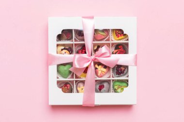 Box with sweet chocolate candies on color background, Various candy sweets. Valentines day gift box. Top view flat lay with copy space.
