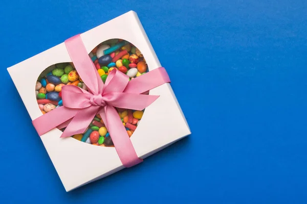 Box with sweet chocolate candies on color background, Various candy sweets. Valentines day gift box. Top view flat lay with copy space.