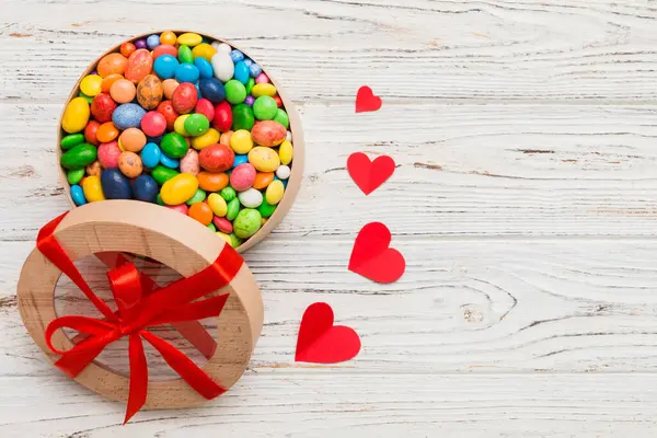 Valentine day composition: sweet candy, with gift boxes with bow and red felt hearts, photo template, background. Top View with copy space.