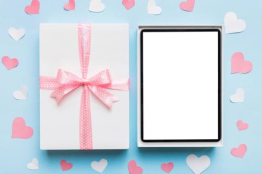 Gift box of open tablet for the holidays with a bow top view.