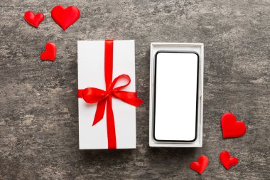 Opened gift box with ribbon and phone on color background, top view. Blank open box packaging mockup , Template for your design - branding mockup.