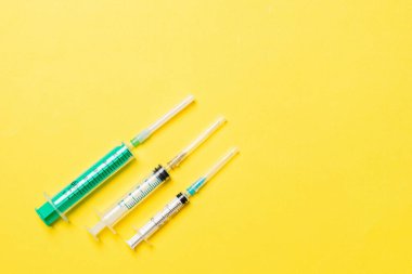Renkli arka planda fotokopi alanı olan tıbbi şırıngaların üst görüntüsü. Enjeksiyon ekipmanı konsepti.