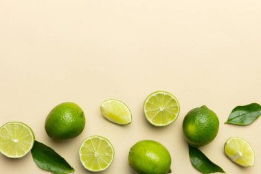 Yeşil yapraklı kireç meyveleri ve beyaz arka planda yarım dilim kesilmiş. Üst Manzara. Kopyalama alanı olan düz.