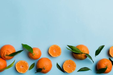 Renkli arkaplanda yeşil yaprakları, üst görünümü, metin için alanı olan bir sürü olgun mandalina..