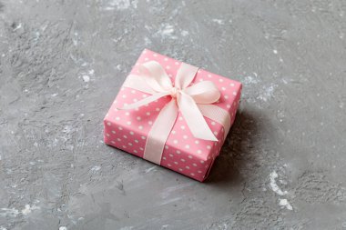 Noel 'i ya da diğer tatil hediyelerini renkli arka planda kurdeleyle renkli kağıda sardım. Şimdiki kutu, renkli tabloda hediye süslemesi, kopya alanı ile üst görünüm.