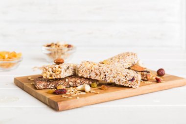 Arka planda çeşitli granola barlar var. Mısır gevreği gofretleri. Yulaf, fındık ve böğürtlenli kahvaltı barları, yakın çekim. Süper yiyecek konsepti.