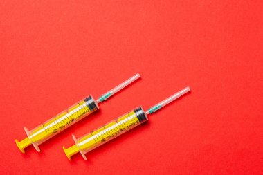 Renkli arka planda fotokopi alanı olan tıbbi şırıngaların üst görüntüsü. Enjeksiyon ekipmanı konsepti.