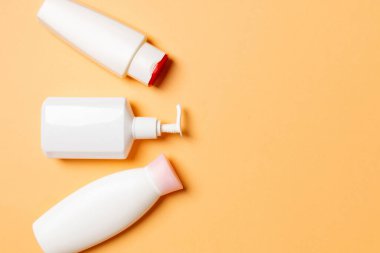 Renkli arkaplanda izole edilmiş Beyaz Kozmetik konteynırları seti, fotokopi alanı ile üst görünüm. Senin için bir grup plastik kaplar ve boş bir yer tasarladın..