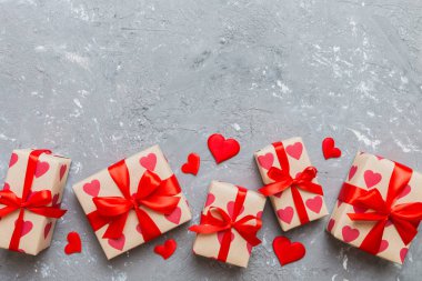 Top view photo of valentine day decorations gift box with red ribbon bow on colored background. Holiday gift boxes with top view.