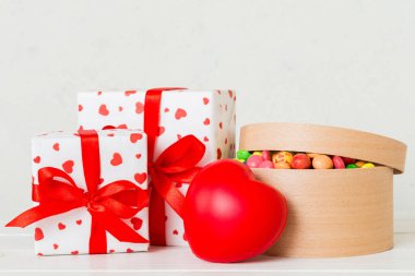 Valentine day composition: sweet candy, with gift boxes with bow and red felt hearts, photo template, background. Perspective with copy space.