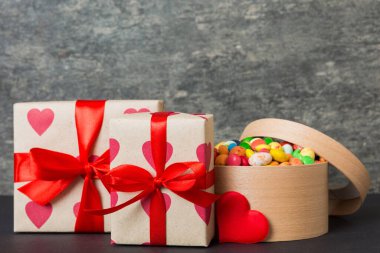 Valentine day composition: sweet candy, with gift boxes with bow and red felt hearts, photo template, background. Perspective with copy space.