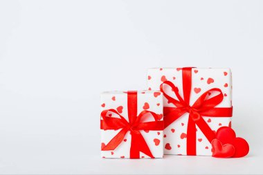 gift box with red bow and red heart on colored background. Perspective view. Flat lay.