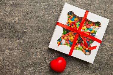Valentine day composition: sweet candy, with gift boxes with bow and red felt hearts, photo template, background. Top View with copy space.