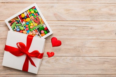 Valentine day composition: sweet candy, with gift boxes with bow and red felt hearts, photo template, background. Top View with copy space.