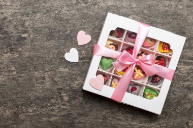 Valentine day composition: sweet candy, with gift boxes with bow and red felt hearts, photo template, background. Top View with copy space.