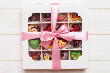 Valentine day composition: sweet candy, with gift boxes with bow and red felt hearts, photo template, background. Top View with copy space.