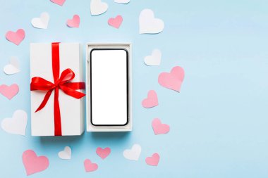 Opened gift box with ribbon and phone on color background, top view. Blank open box packaging mockup , Template for your design - branding mockup.