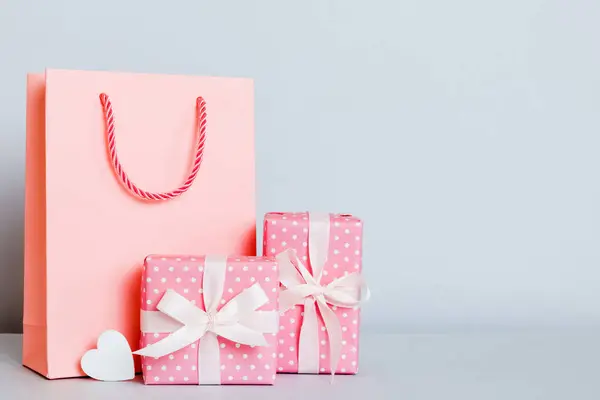 Shopping bag with gift box on colored background perspecrive view. Space for text holiday concept.