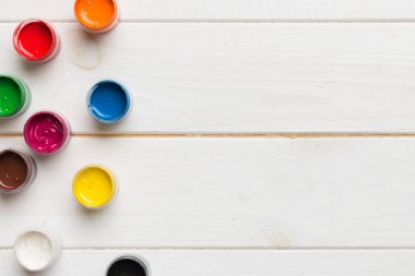 Renkli arka planda farklı renkte gagalı kavanozlar. Hobi resim. Boşluğu olan üst görünüm. Yaratıcılık için işyeri. ev öğretmenliği kavramı çizimi.