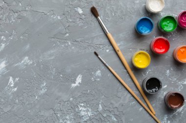 Boya ve fırçalı palet, yakın çekim. Boşluğu olan üst görünüm. Yaratıcılık için işyeri. ev öğretmenliği kavramı çizimi.