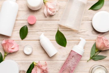 Kozmetik ürünleri ve ahşap arka planda güzel güller olan kompozisyon. Düz yatıyordu.