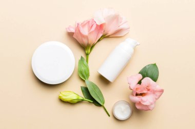 Renkli arka planda kozmetik ürünleri ve güzel güller olan kompozisyon. Düz yatıyordu.