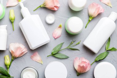 Kozmetik ürünleri ve çimento arka planında güzel güller olan kompozisyon. Düz yatıyordu.