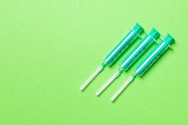 Renkli arka planda fotokopi alanı olan tıbbi şırıngaların üst görüntüsü. Enjeksiyon ekipmanı konsepti.