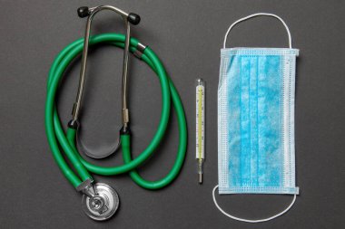 Stetoskop, tıbbi koruyucu maske ve renkli arka planda termometre. Tıbbi aksesuarlar konsepti .