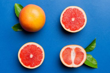 Renkli arka planda sulu greyfurt dilimli taze meyve greyfurdu. Üst Manzara. Uzayı kopyala yaratıcı yaz konsepti. Minimum düzlükte turunçgillerin yarısı kopyalama alanı ile yatar.