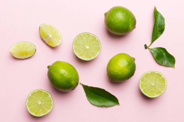 Yeşil yapraklı kireç meyveleri ve beyaz arka planda yarım dilim kesilmiş. Üst Manzara. Kopyalama alanı olan düz.