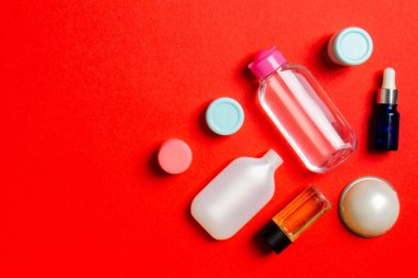 Kozmetik SPA marka modeli, fotokopi alanı olan üst görünüm. Renkli arka planda duran krema tüpleri ve kavanozları..