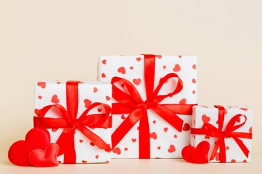gift box with red bow and red heart on colored background. Perspective view. Flat lay.