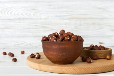 Wooden bowl full of hazelnuts on table background. Healthy eating concept. Super foods.