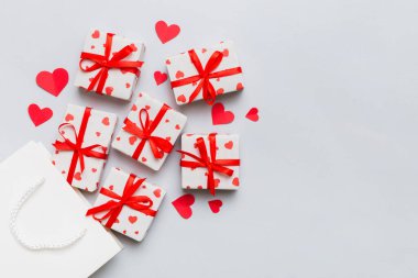 Gift boxes pop out from paper bag top view on colored background. bag packing handmade boxes fall out Concept of holidays, shopping, sale, discounts. Top view, flat lay.