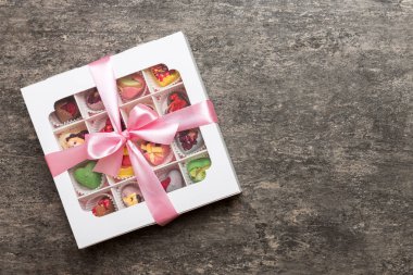 Box with sweet chocolate candies on color background, Various candy sweets. Valentines day gift box. Top view flat lay with copy space.