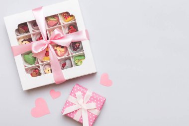 Valentine day composition: sweet candy, with gift boxes with bow and red felt hearts, photo template, background. Top View with copy space.