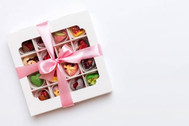 Box with sweet chocolate candies on color background, Various candy sweets. Valentines day gift box. Top view flat lay with copy space.
