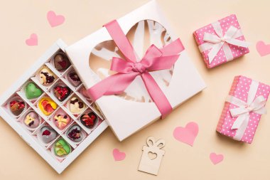 Valentine day composition: sweet candy, with gift boxes with bow and red felt hearts, photo template, background. Top View with copy space.