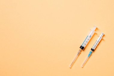 Renkli arka planda tıbbi şırıngaların üst görüntüsü. Fotokopi alanı ile sağlık hizmeti kavramı.