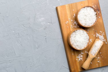 Ahşap bir arka planda ahşap bir kase tuz kristali. Kırsal kaselerdeki tuz, fotokopi alanı olan üst görünüm.