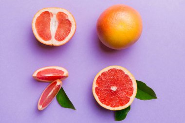 Renkli arka planda sulu greyfurt dilimli taze meyve greyfurdu. Üst Manzara. Uzayı kopyala yaratıcı yaz konsepti. Minimum düzlükte turunçgillerin yarısı kopyalama alanı ile yatar.