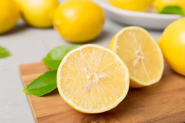 Kesme tahtasındaki taze ve olgun limonlar için fotokopi alanı olan üst manzara. Sağlıklı yemek geçmişi. Limon ve limon dilimlerinin zarif arkaplanı daha sıkan renkli arkaplan.
